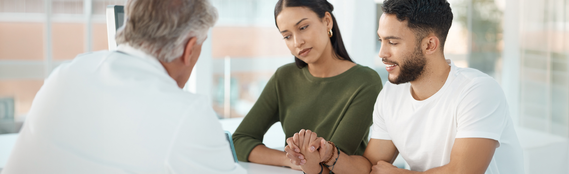 A couple consults with a doctor about in vitro fertilization, discussing options and support.