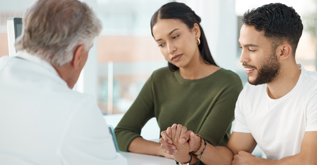 A couple consults with a doctor about in vitro fertilization, showing concern and support for each other.